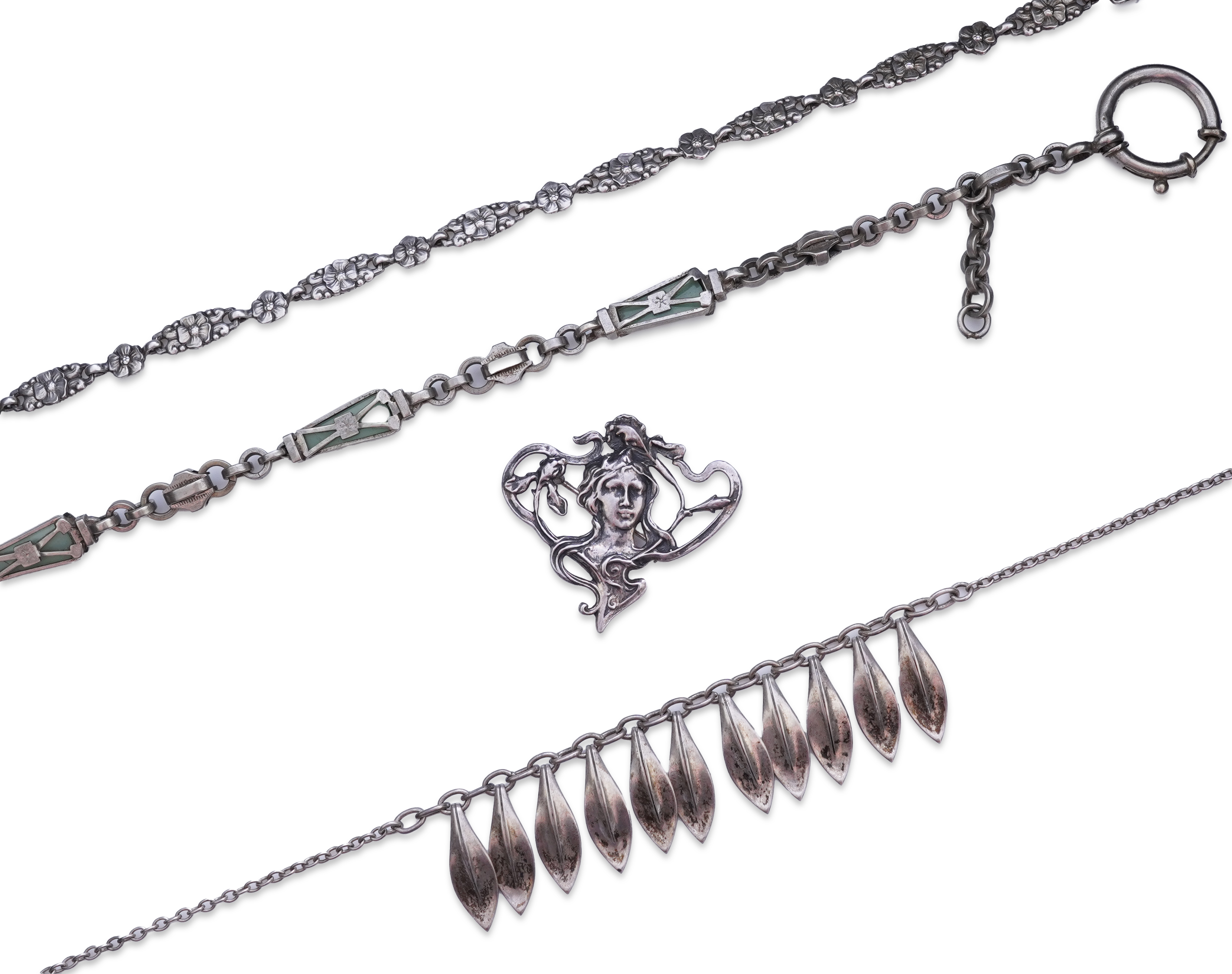 A collection of three silver chains and an Art Nouveau brooch, early 20th century